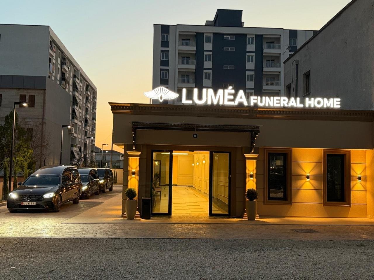 Fasada e Luméa Funeral Home në Vlorë në mbrëmje, me hyrjen dhe ndriçimin e ndezur.